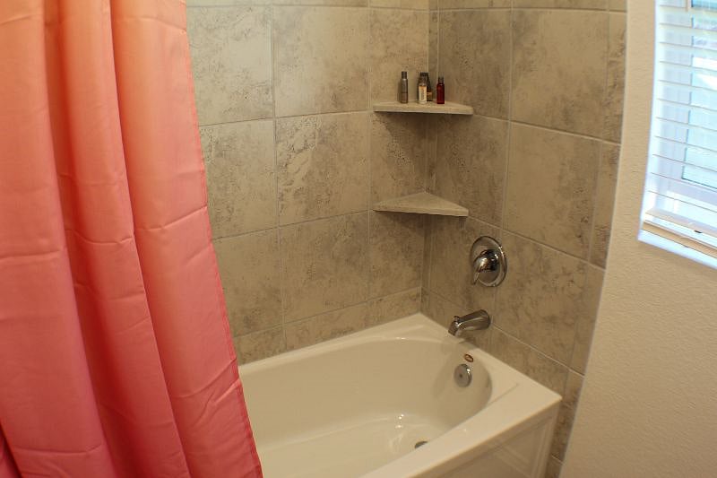 The front bathroom comes with a bathing tub and shower.