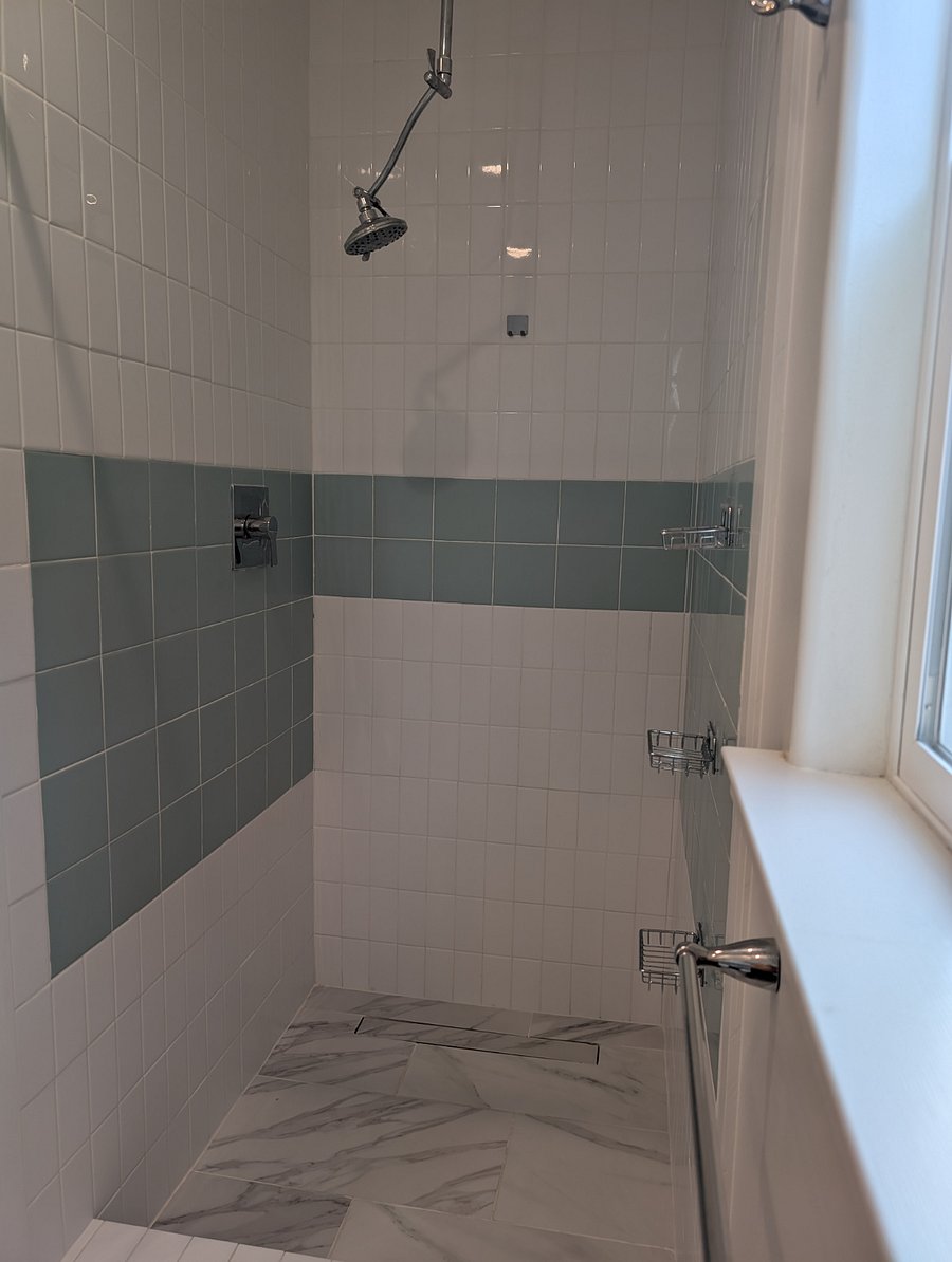 Private bathroom with tiled shower.
