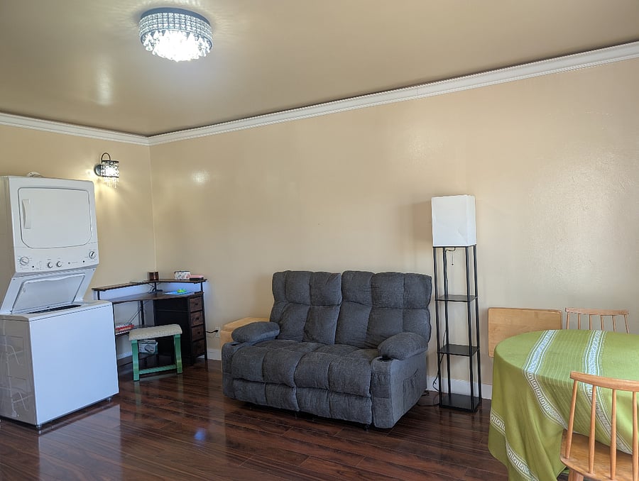 Living Room features a reclining love seat, washer/dryer unit, corner desk, and small dining room table and chairs.