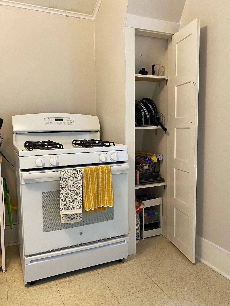 kitchen stove on west wall with storage to the right.