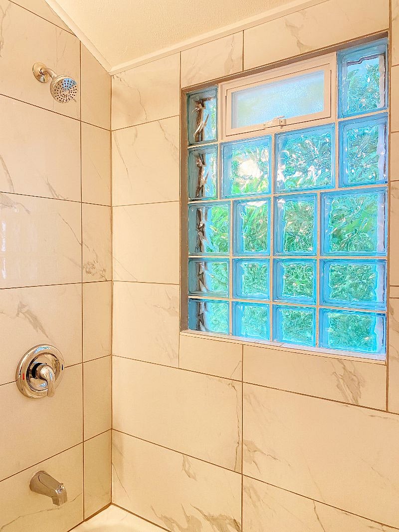 Bathroom Shower and window with a small window. There is also a fan which vents to the outside.