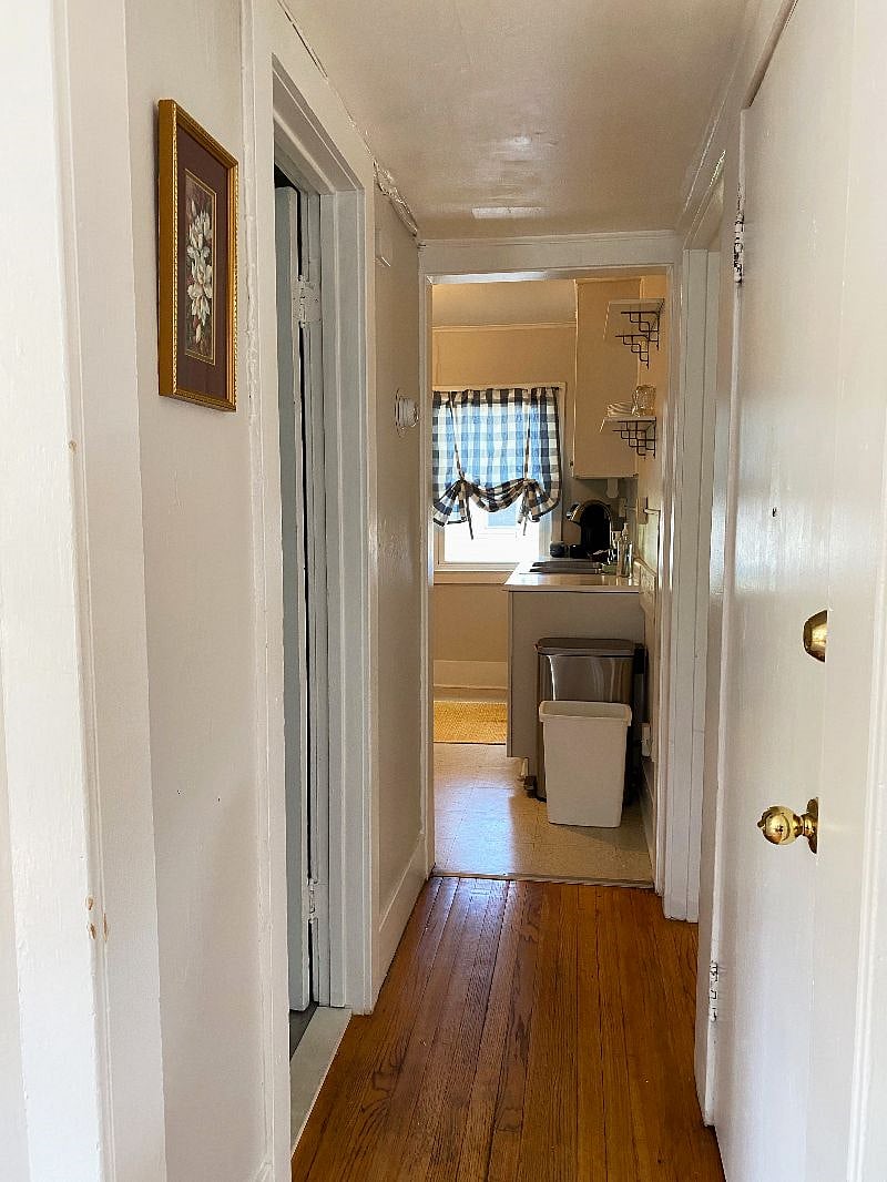 view of hallway from the living room looking north to the kitchen. front entrance on the right followed by the bedroom, bathroom on the left.