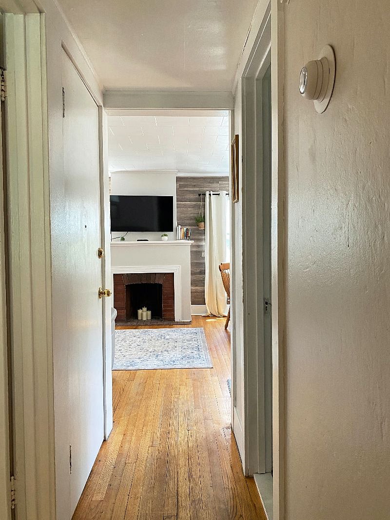 view from the kitchen looking south down the hallway. Bedroom is the first door on the left, followed by the entrance, bathroom is on the right.