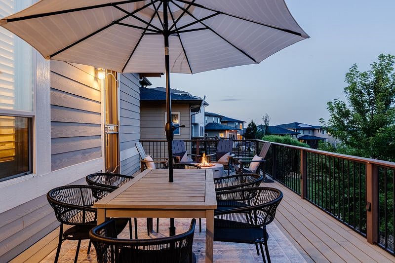 One of two outdoor entertainment areas. The upper deck includes a wood dining table + seating for 6, collapsable umbrella, outdoor rug, propane fire pit + 4 Adirondack chairs. Easy living.