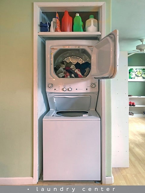 a stack washer dryer is centrally located across from the kitchen island.