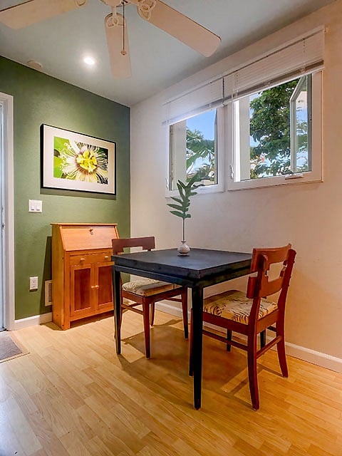 this inside dining and work table easily transforms to double its surface area. tropical images by James  Kastner adorn the walls.