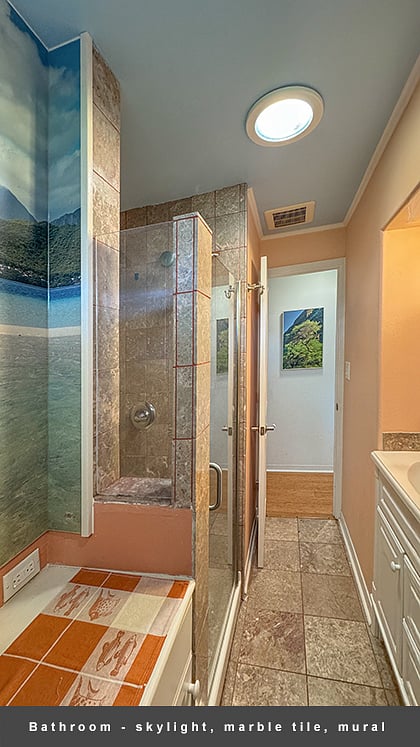 The bathroom features a beautiful marble tiled shower and floor.