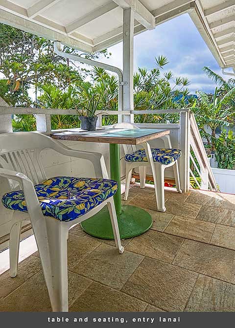 A cafe table and two padded chairs await at the top of the entry stairway, perfect for morning coffee and a chat with a friend.
