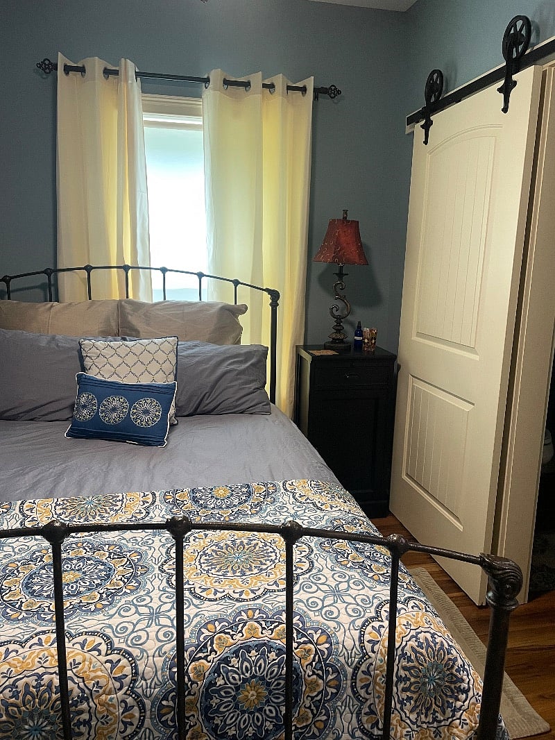 Comfortable queen size bed with adjacent bathroom.