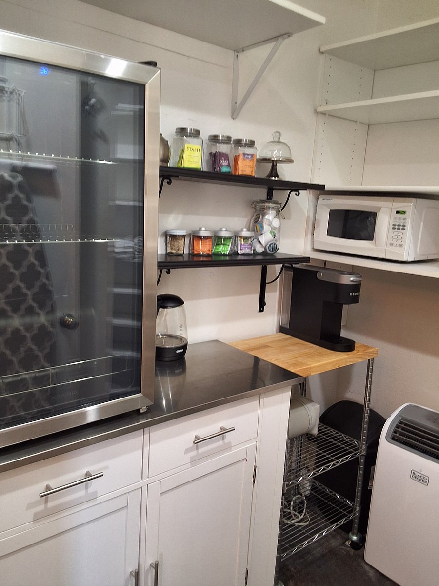 Primary bedroom walk-in closet with beverage refrigerator, microwave and coffee bar