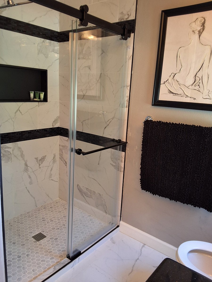 Primary bathroom with newly tiled shower and rain shower head