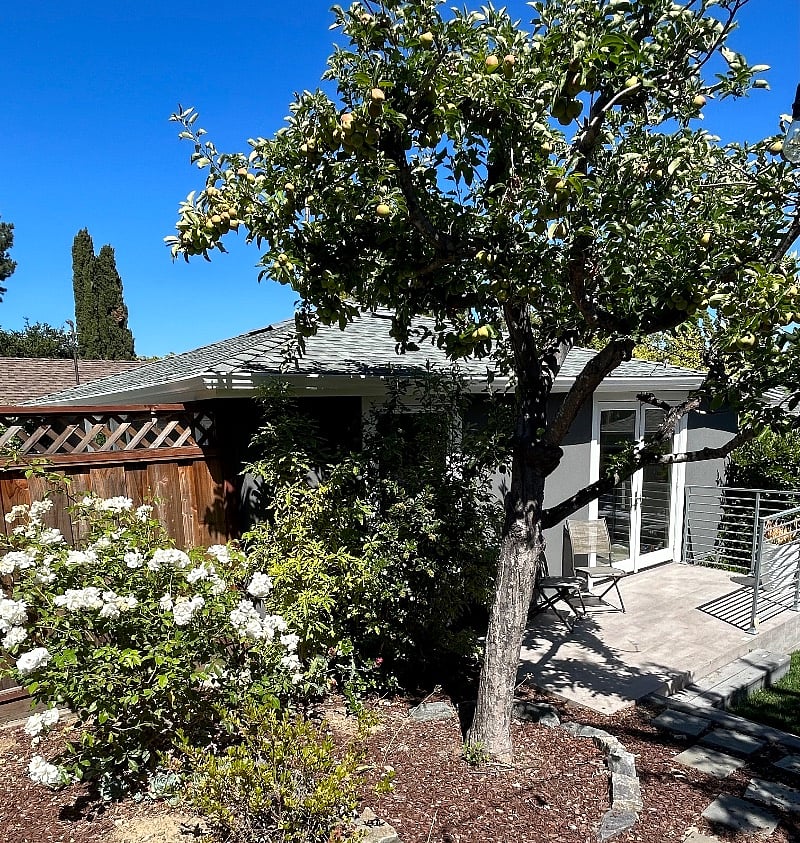 Front of Cottage with terrace and two chairs and fountain