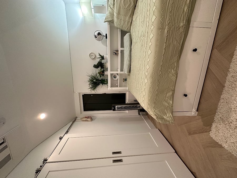 Full private bedroom with skylight with electronic shade and full-length mirror. Bedroom has barn doors that close to main area.
