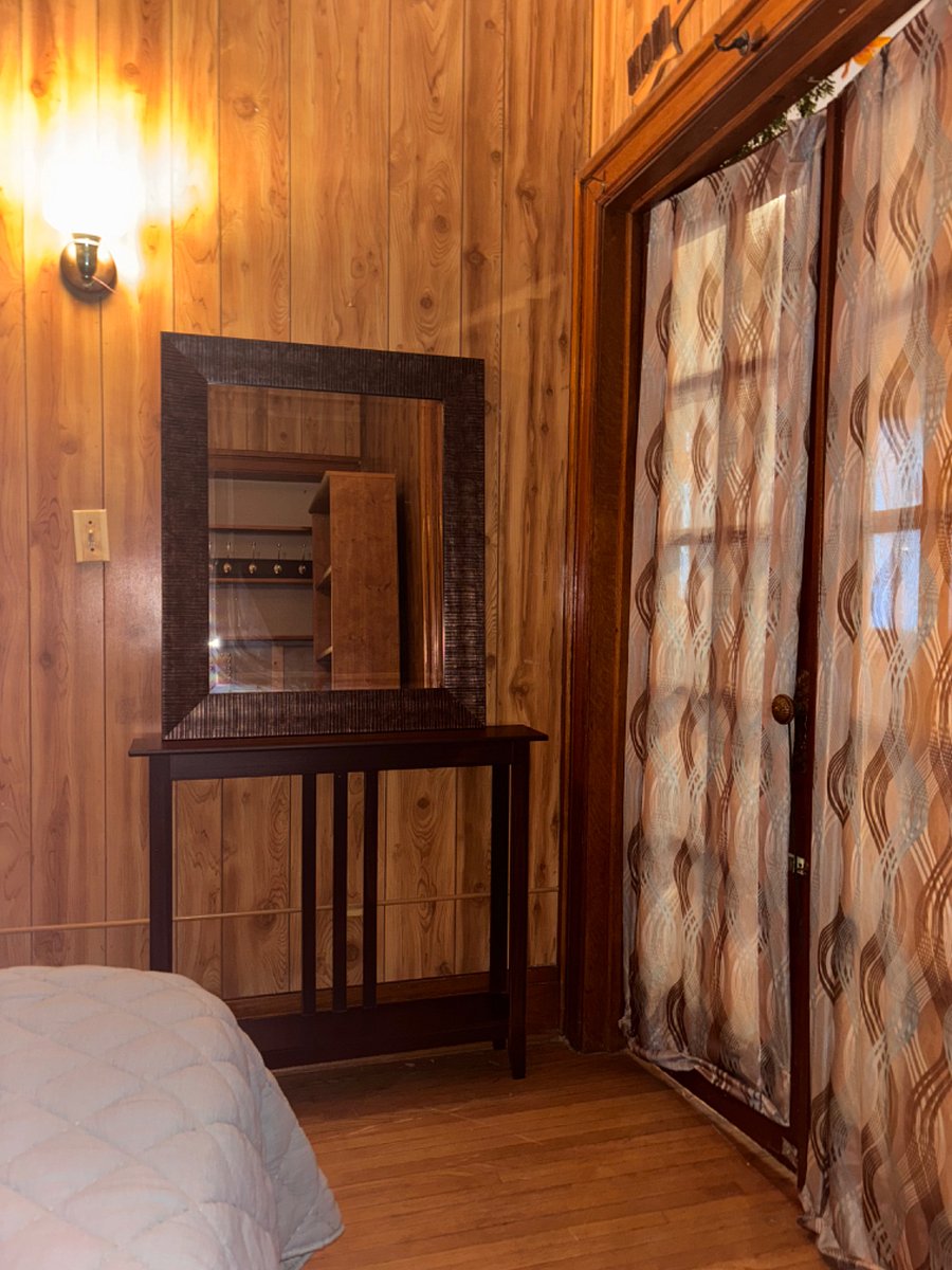 Bedroom one off the living room has full size bed, night stand, mirror with table, book case shelf 