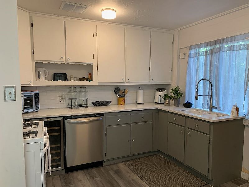 Kitchen, lots of utensils, plates, bowls, glasses, pots and cooking items.  
