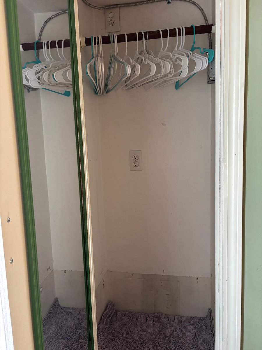 Closet space with hangars and full length mirror 