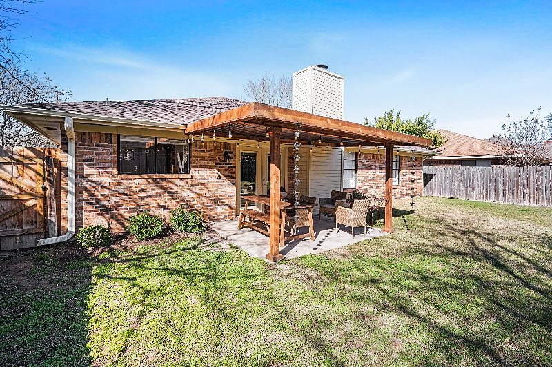 Backyard with covered porch, outdoor dining area and fully fenced with privacy fence.  
