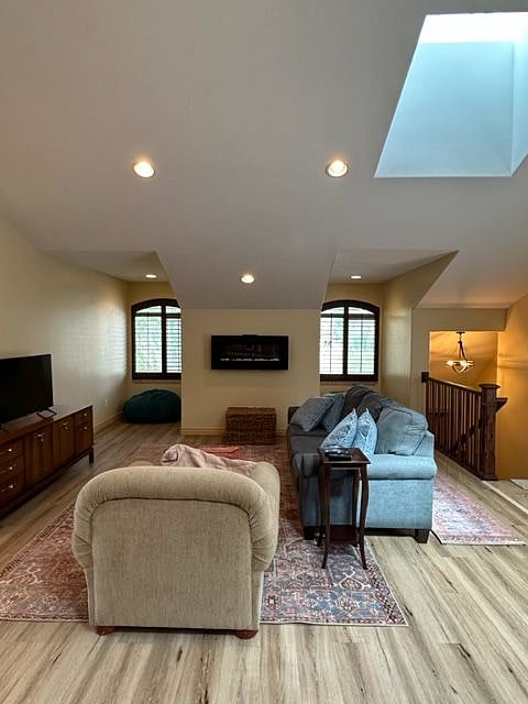 Living room with an electric fireplace, 2 little alcove windows facing the East mountains and high ceilings with 2 skylights for extra warmth and brightness. 