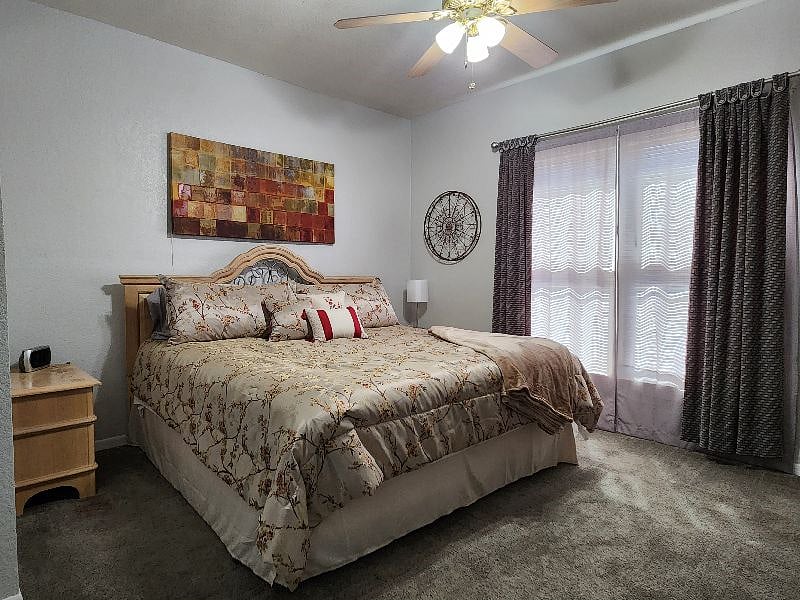 Spacious primary bedroom with a king-size bed, ceiling fan, and plenty of room to move around comfortably. Bedding provided.