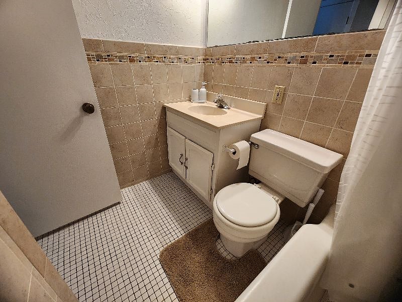 Well-kept bathroom with tile surround and a full tub/shower combination.