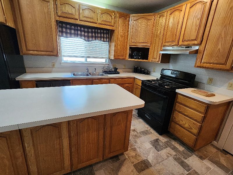 A cook-friendly kitchen with a large prep island, plenty of storage, gas stove, and microwave. Pots, pans, cooking utensils, and dishware are provided, too.