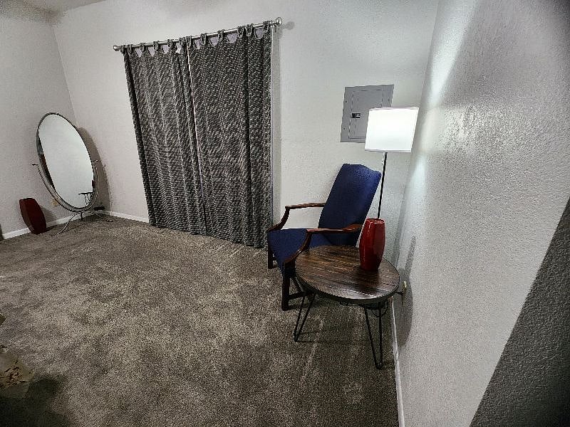 Roomy primary bedroom with a comfortable sitting area, four windows for plenty of natural light, a full-length mirror, and that all-important Texas ceiling fan.