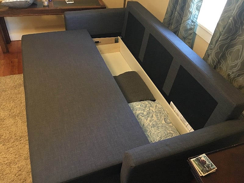 Couch folds out into full size bed.  Mattress pad and bedding in storage area.
