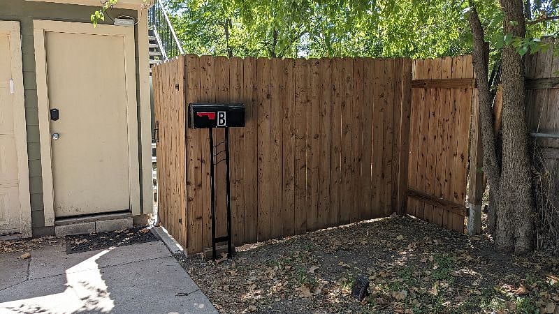 Gate and fence separating garage apartment from main house backyard.