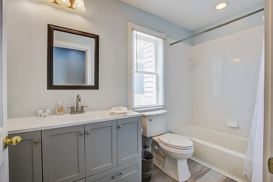 Convenient upstairs full bathroom featuring a relaxing bathtub for unwinding after a long shift, plus plenty of storage for your essentials.