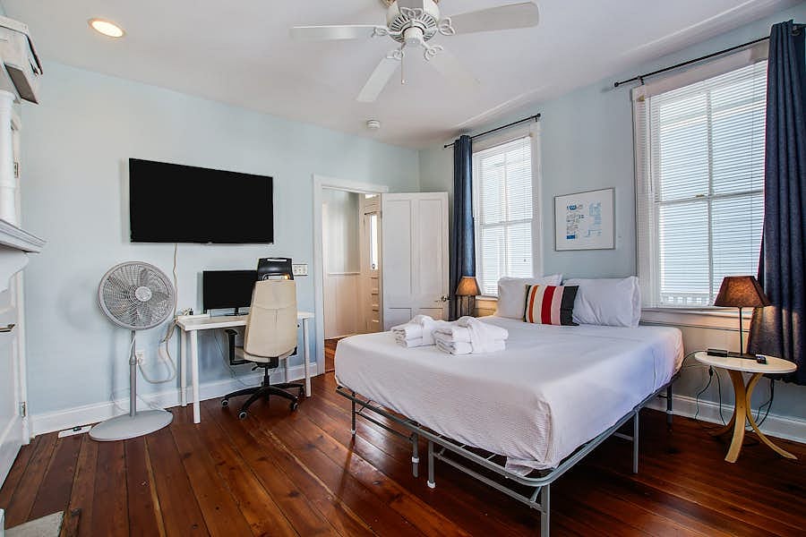 Bright ground-floor front bedroom with ample natural light and queen bed. Smart TV and work station.