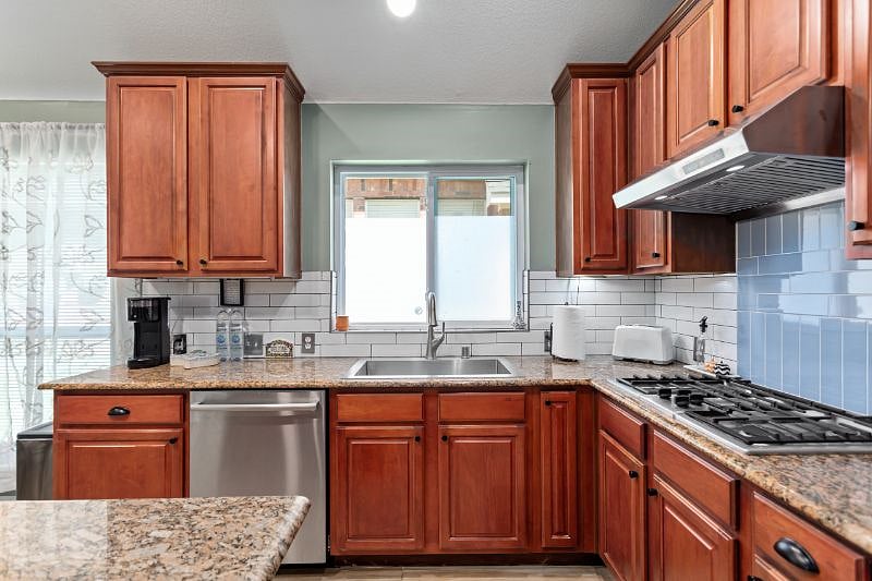 SS Bosch stove & venthood vents outside the house, SS dishwasher, single large kitchen sink over window, granite counters.
