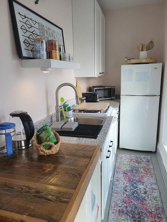 KItchen with refrigerator, stovetop and oven, microwave, toaster, coffee press and automatic drip coffee maker. Plates, pans and dinnerware provided.