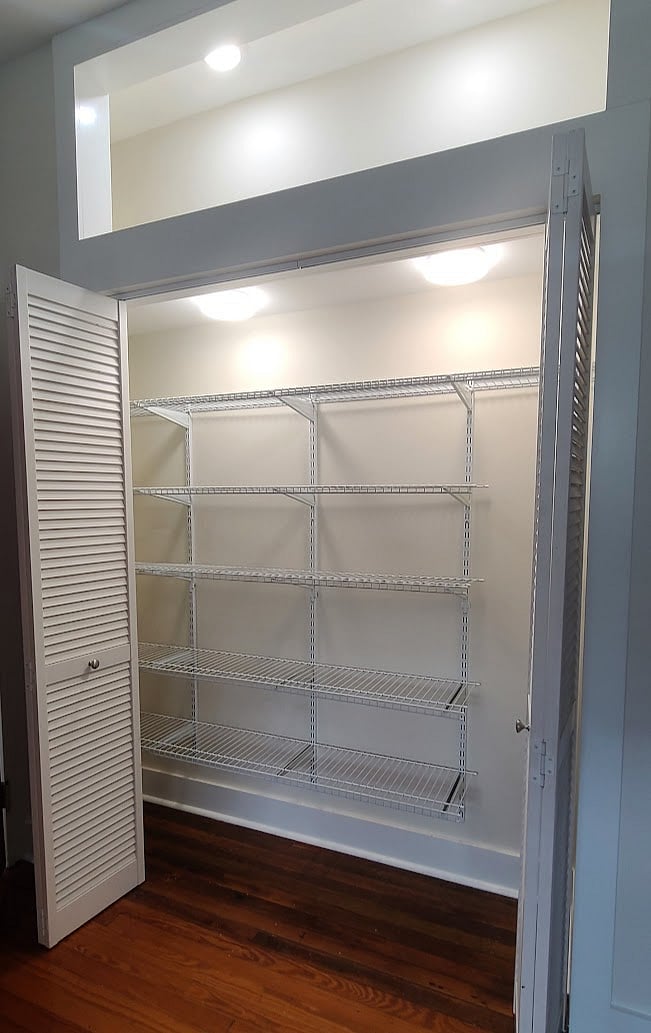 Large kitchen pantry with lighting and adjustable shelving.