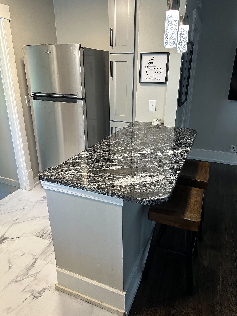 A small house, still gives you a place to eat your meals with this granite bar.