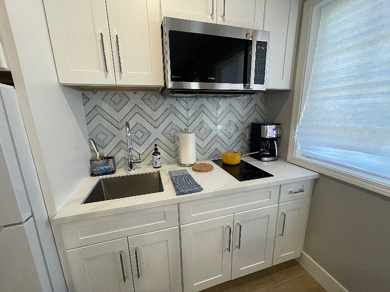 Efficient fully equipped kitchen with 2 burner stove, combo microwave/air fryer/steamer oven, blender, toaster, pots + pans, dinnerware, knives, starter spices + cooking oils, drip coffee maker and midsize refrigerator. Plenty of kitchen storage.