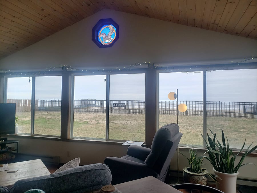Wall of windows (that open) in living room with updated roller shades.
