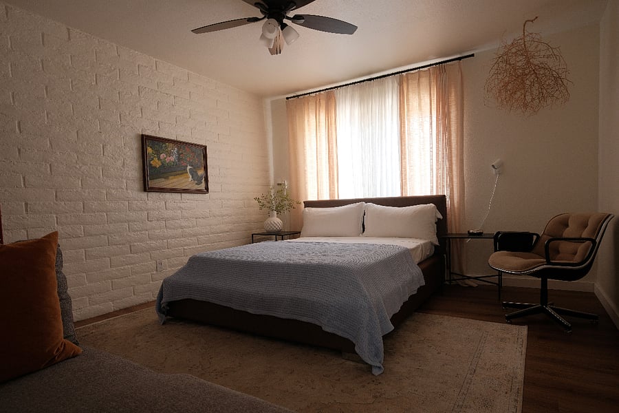 Guest bedroom next to guest bathroom window looking outside. Knoll vintage chair with small desk attachment. Small sofa.