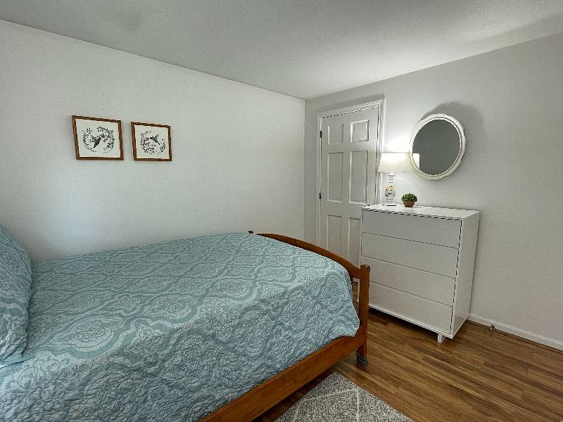 Hardwood floors and an area rug next to your bed.