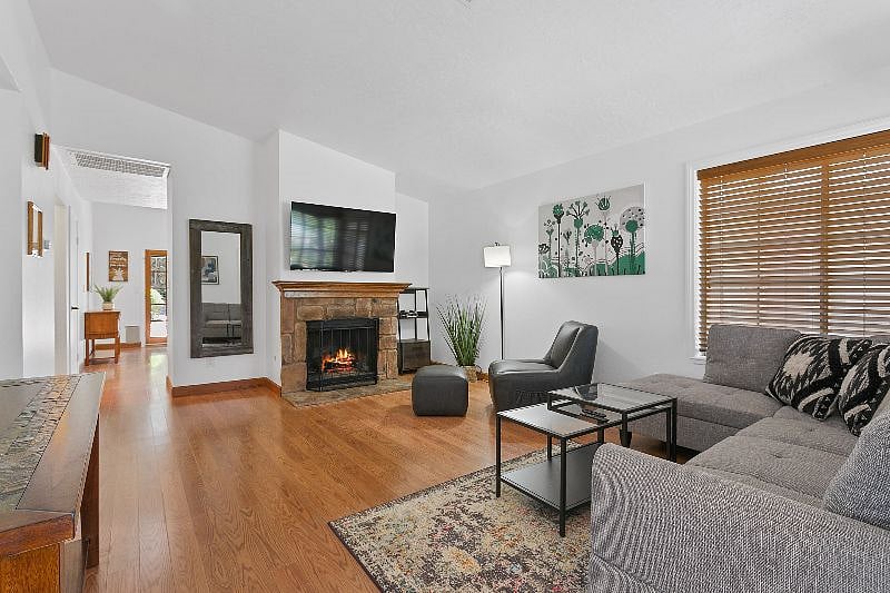 Large screen TV and wood burning fireplace highlight the living room.