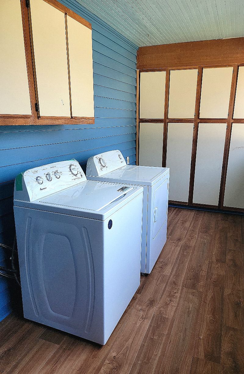 Washer and dryer in laundry area with ample storage and utility cabinets