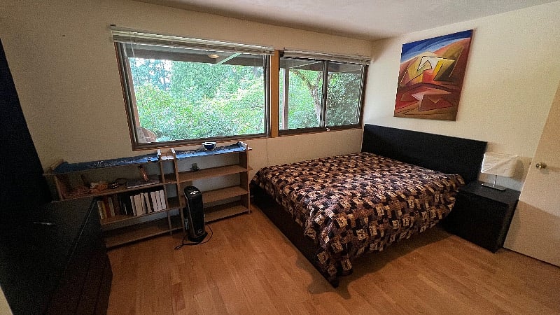 Bedroom 2. Queen bed, closet and drawers for storage, view to the garden