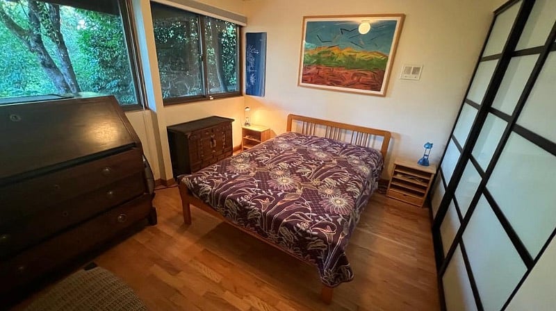 Bedroom 1. Full bed, wall to wall closet and drawers for storage, view to the garden
