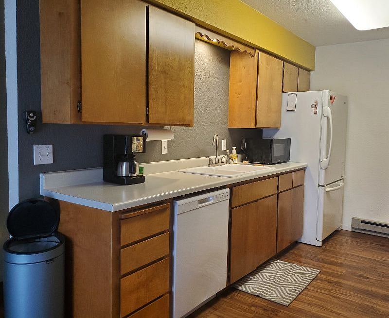 Kitchen, with full size fridge, dishwasher and microwave.
Full size electric range visible in other photo.
