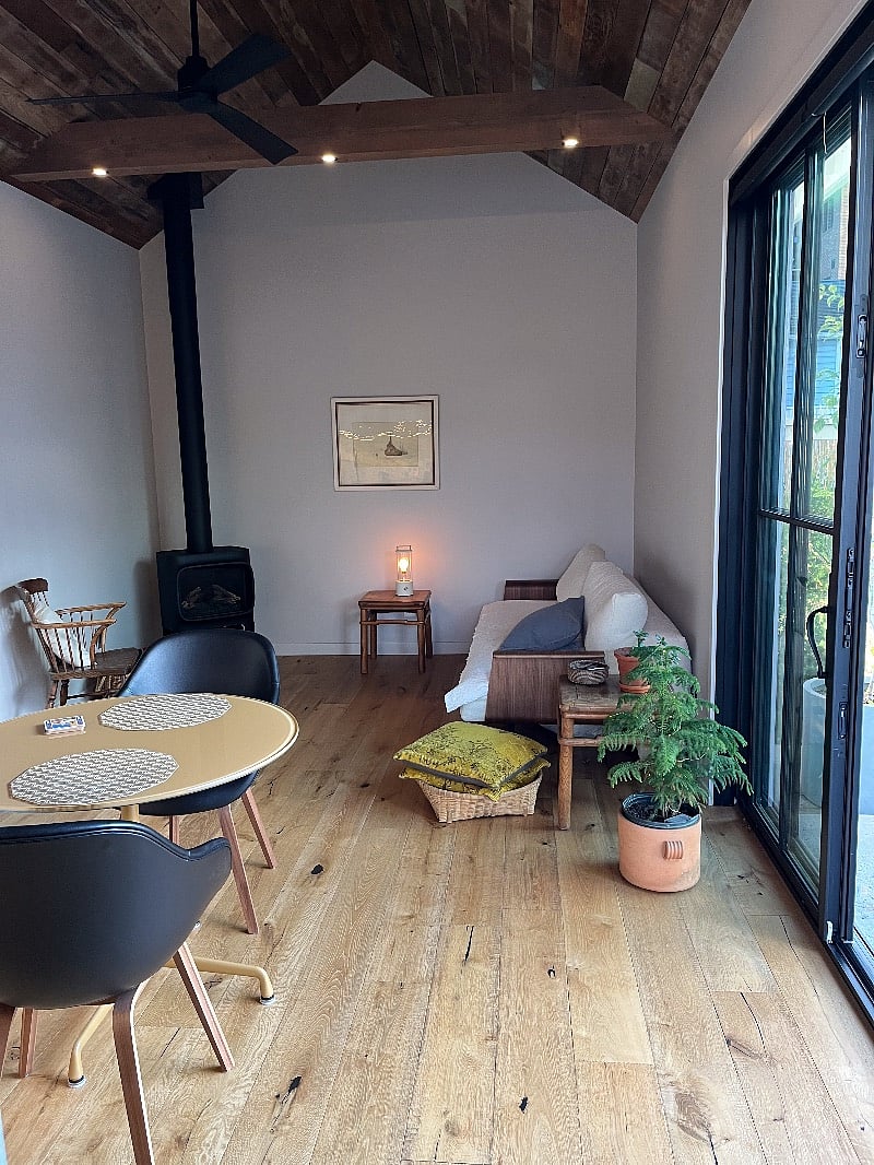 Studio space features oak flooring, gas fireplace, couch that opens to queen bed.