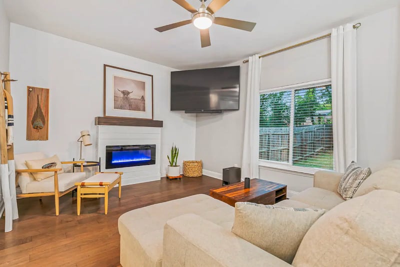 Living Room with lots of natural light, 75" smart TV, fireplace that can be used as a heat source or simply an ambiance. 