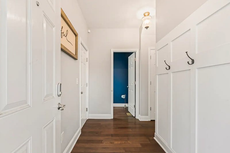 Entry Hallway with half bathroom for guest use. Hooks for jackets and the second entry door to the garage. 