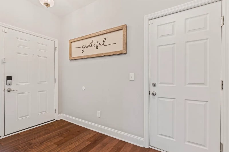 Entry Hallway with half bathroom for guest use. Hooks for jackets and the second entry door to the garage. 