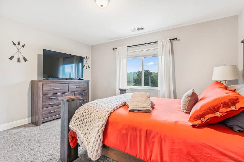 Guest Bedroom with Queen sized bed, lots of dressers, closet, and 55" Smart TV. 