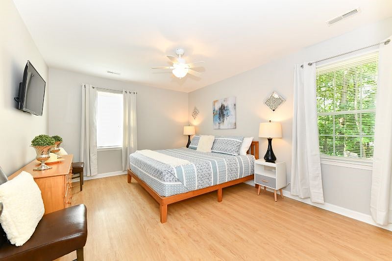 primary room with king bed, side tables, hybrid mattress, mart tv, dresser, chairs, double closets