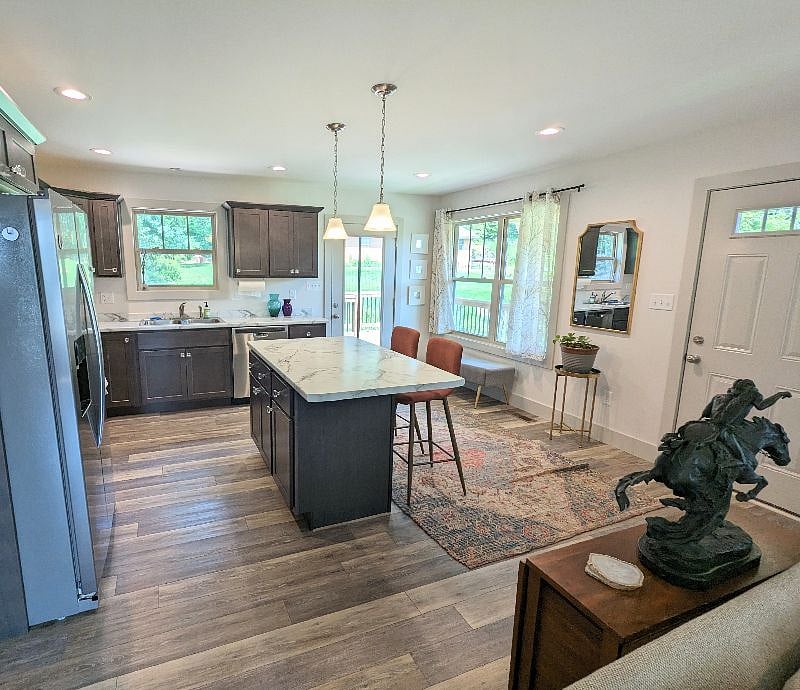 From the kitchen, you can see both the deck and the pasture in front of the house. The island makes for an easy place to eat, and we keep there additional stools in the laundry room. The brown table (under the statue), folds out into a full-size dining table.